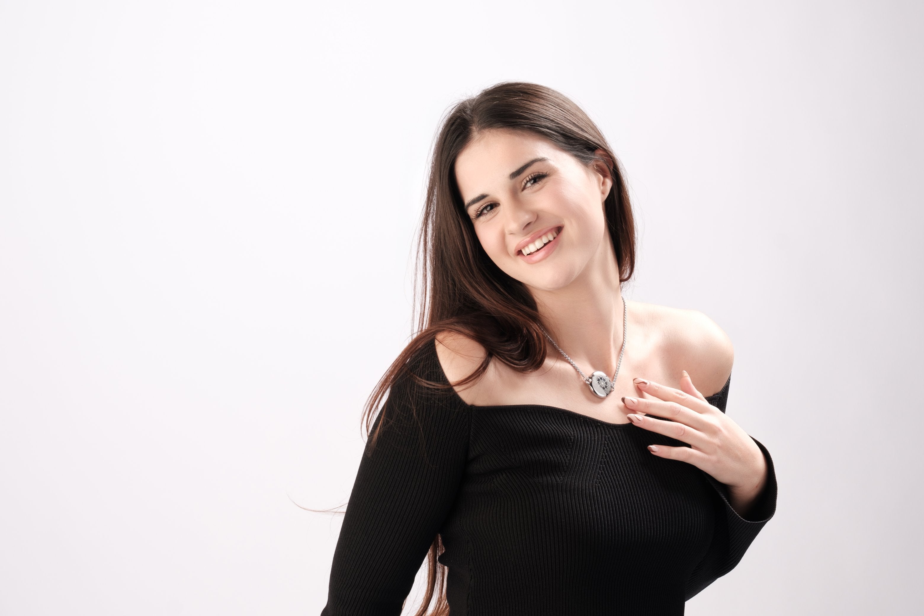Smiling woman wearing ResQ stylish safety necklace - fashionable women's protection jewelry and wearable security device for personal safety and emergency protection.