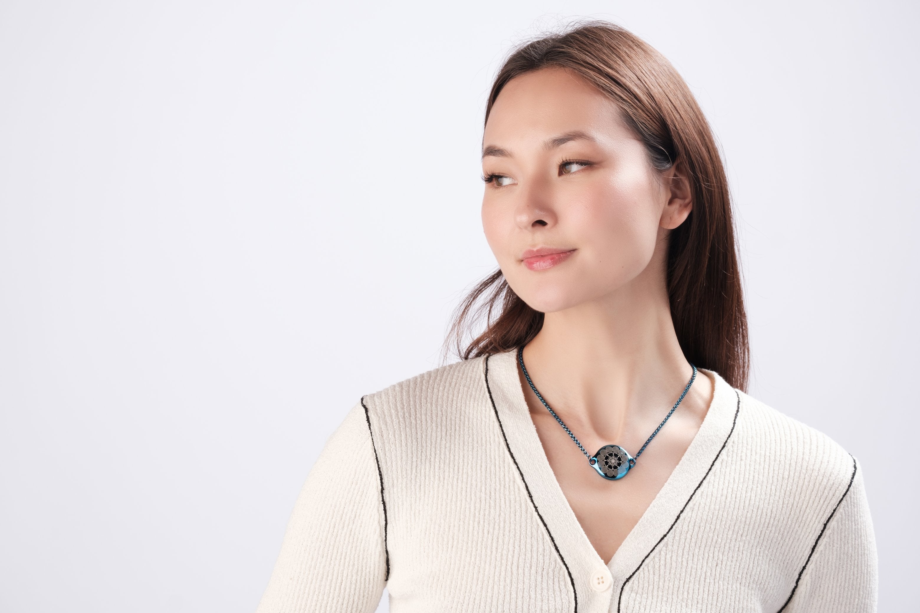 Woman wearing ResQ wearable safety device - stylish heart pendant necklace for women's personal protection and emergency safety, fashionable security jewelry