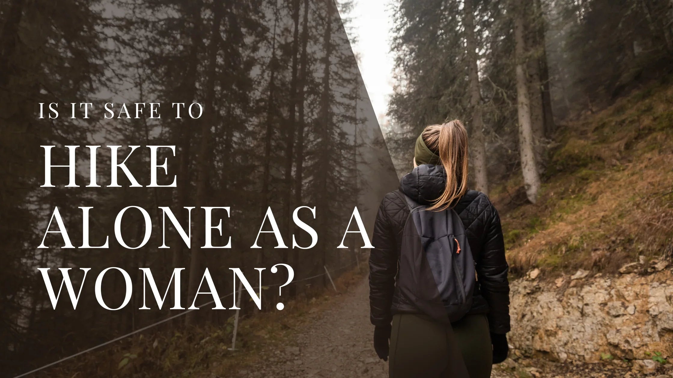 A woman with a backpack hikes alone on a forest trail surrounded by tall trees and mist, walking through a quiet and rugged natural landscape.