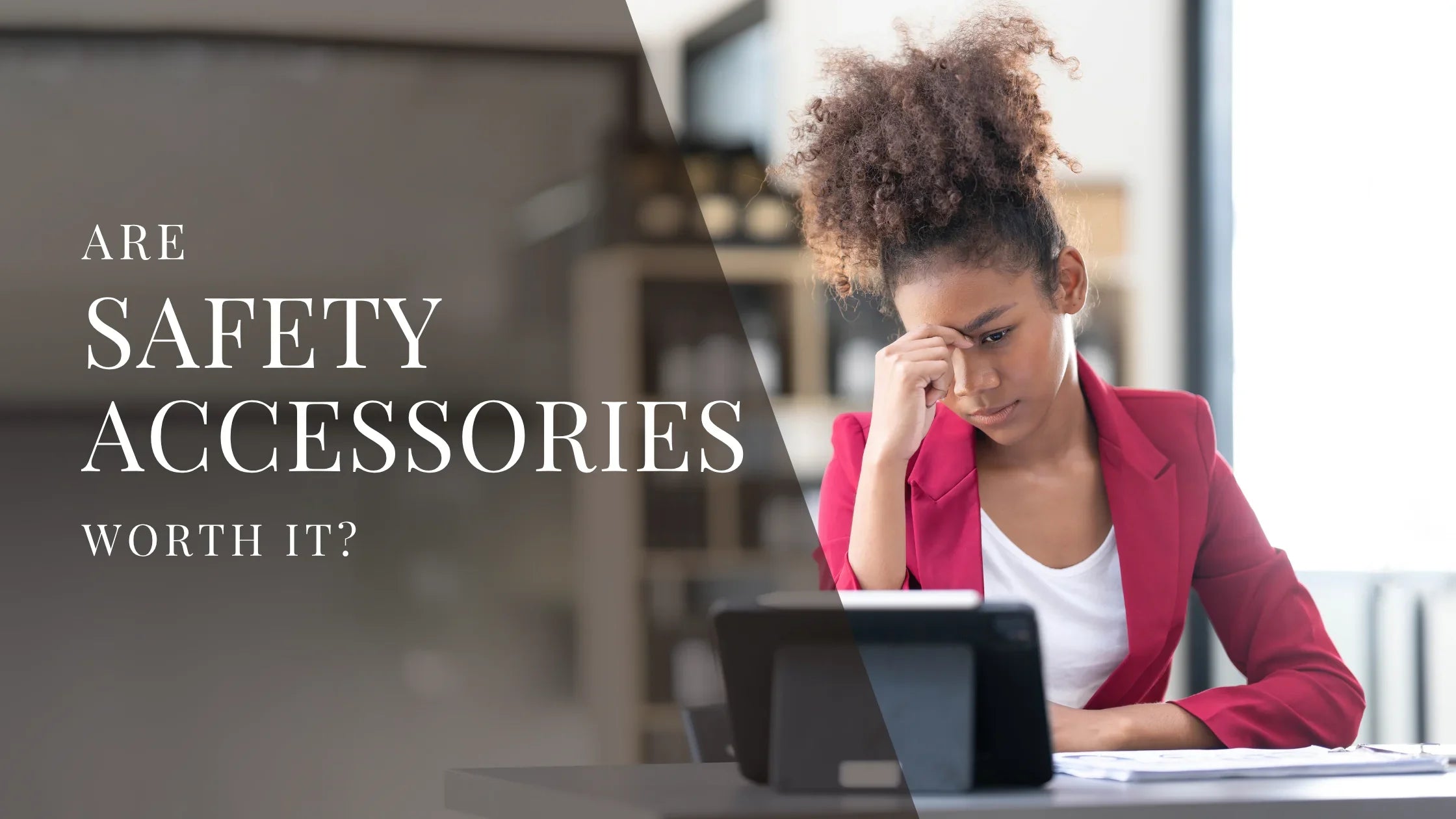 Woman in a red blazer sitting at a desk and looking stressed while working on a tablet, with overlaid text that reads Are Safety Accessories Worth It?