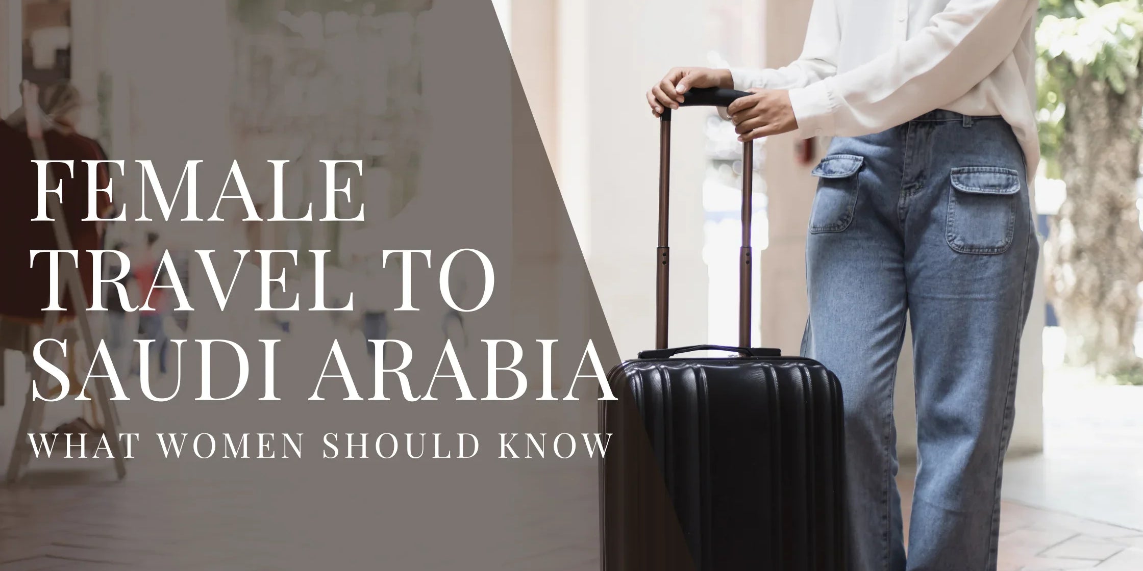 Woman wearing a white blouse and jeans standing indoors with a rolling suitcase, with overlaid text that reads Female Travel to Saudi Arabia What Women Should Know.