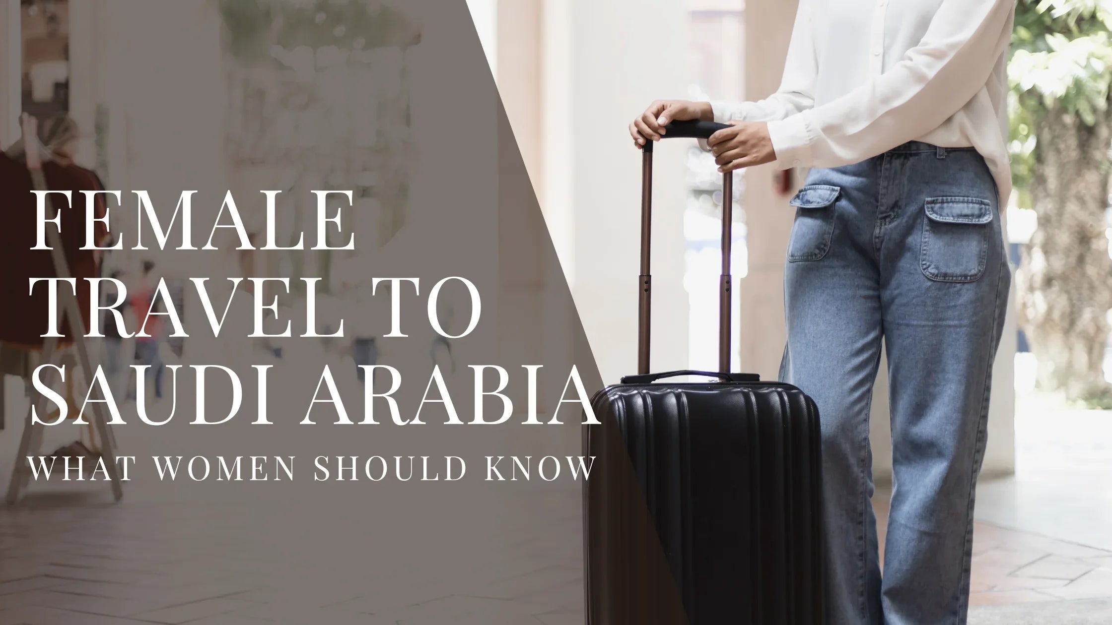 Woman wearing a white blouse and jeans standing indoors with a rolling suitcase, with overlaid text that reads Female Travel to Saudi Arabia What Women Should Know.