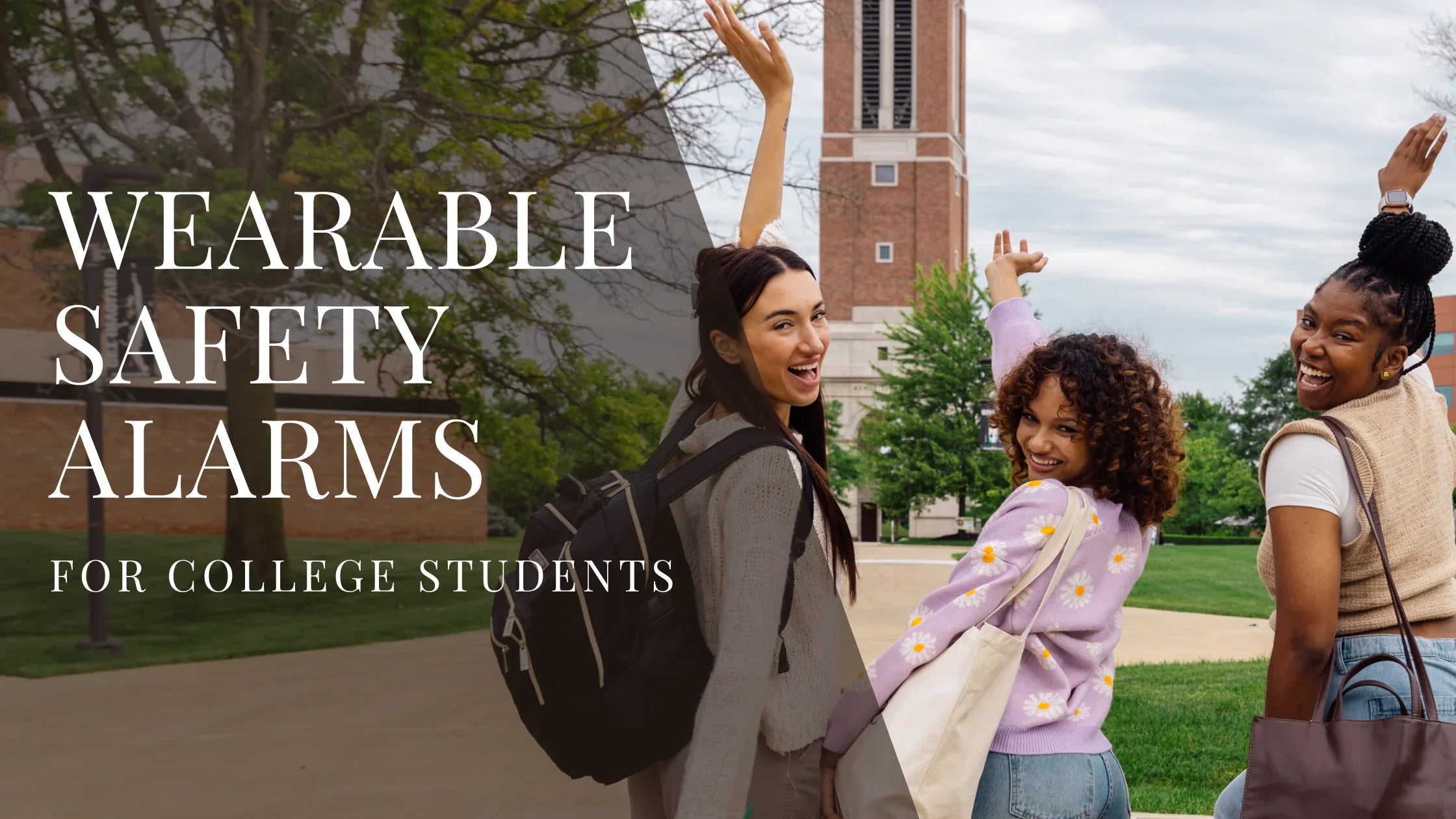Three college students walk together on campus, smiling and raising their arms playfully, with a brick clock tower and green trees in the background.