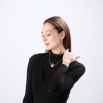 Elegant woman modeling ResQ safety necklace.