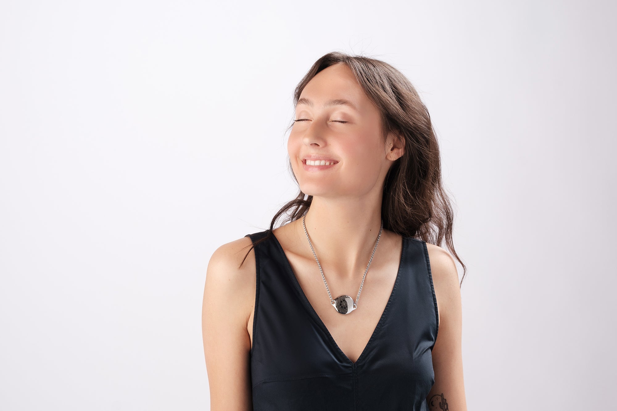 Smiling woman modeling ResQ safety necklace - stylish personal security jewelry for women's peace of mind and protection