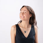 Smiling woman modeling ResQ safety necklace - stylish personal security jewelry for women's peace of mind and protection