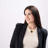 Smiling professional woman wearing ResQ safety necklace - stylish personal security jewelry for women's security