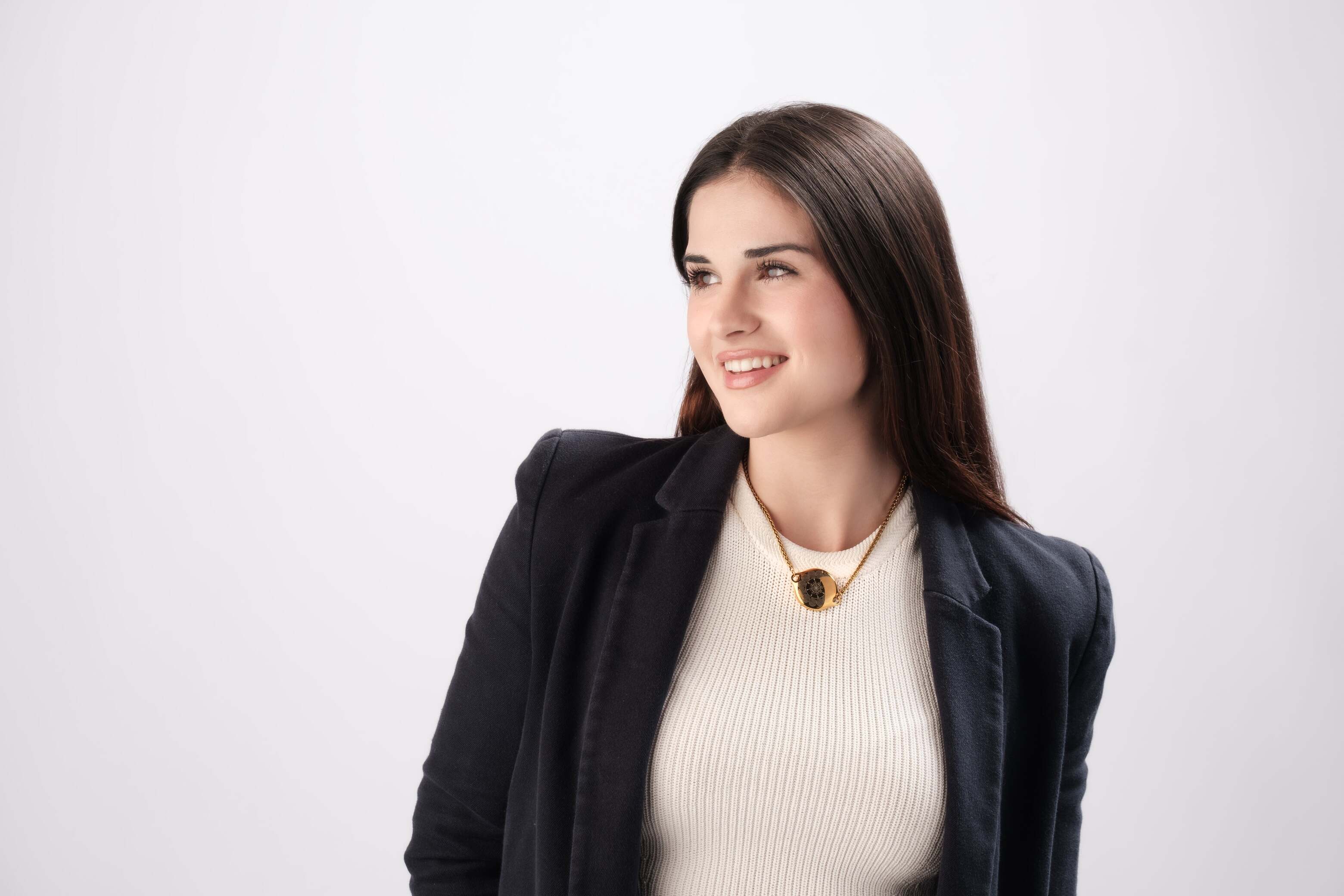 Smiling professional woman wearing ResQ safety necklace - stylish personal security jewelry for women's security