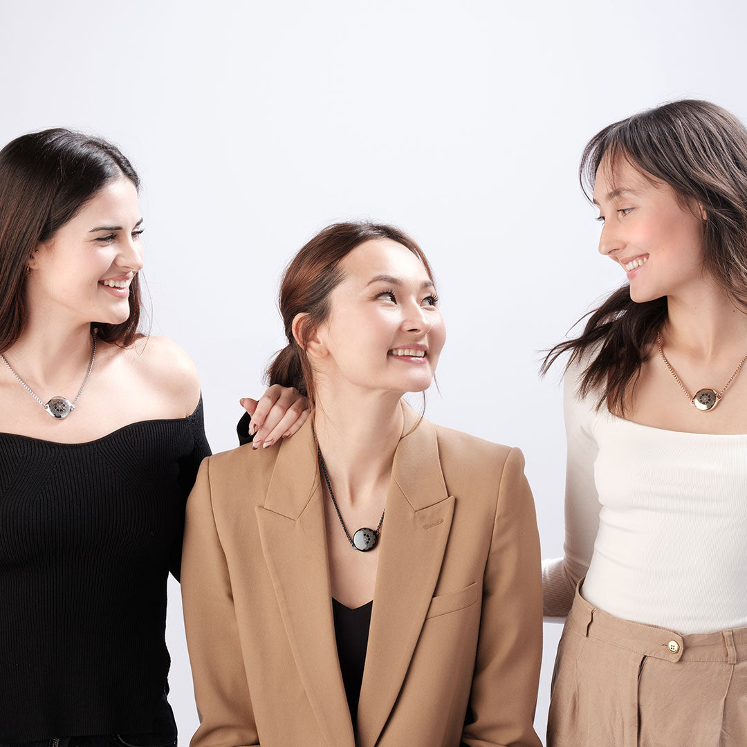 Three women wearing ResQ smart safety necklaces, showcasing fashionable personal protection devices, ideal for women’s everyday safety and security.