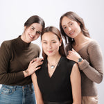 Three women friends wearing ResQ safety jewelry.
