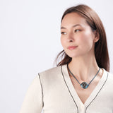 Woman wearing ResQ wearable safety device - stylish heart pendant necklace for women's personal protection and emergency safety, fashionable security jewelry