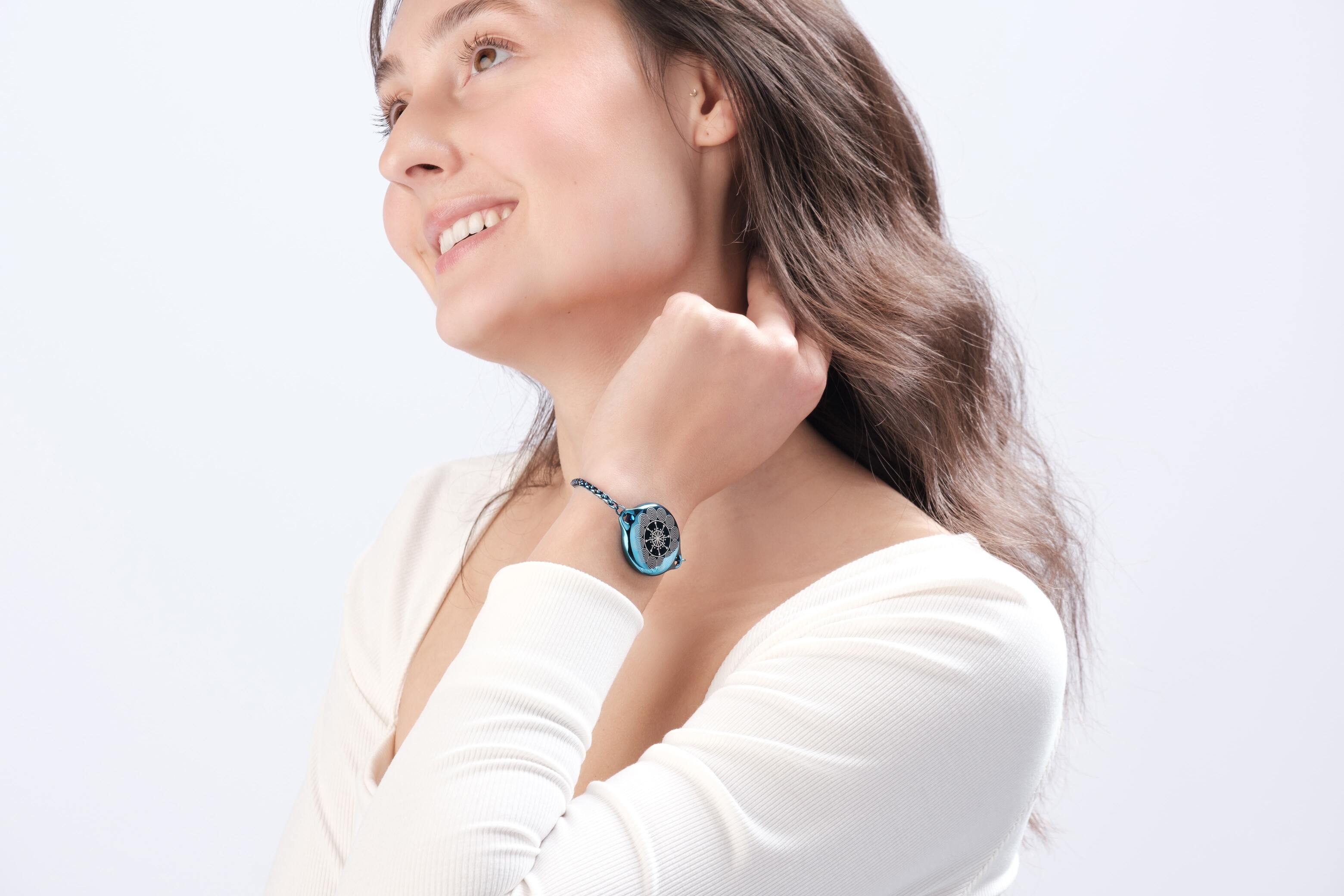 Woman modeling fashionable safety bracelet by ResQ - elegant wearable personal alarm device for women's security.